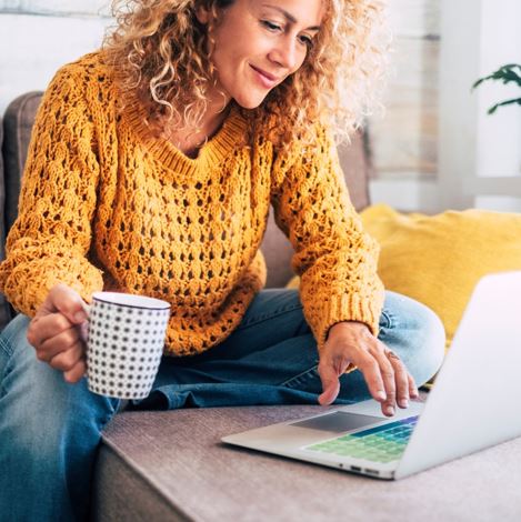 woman working on laptop with cup of coffee
