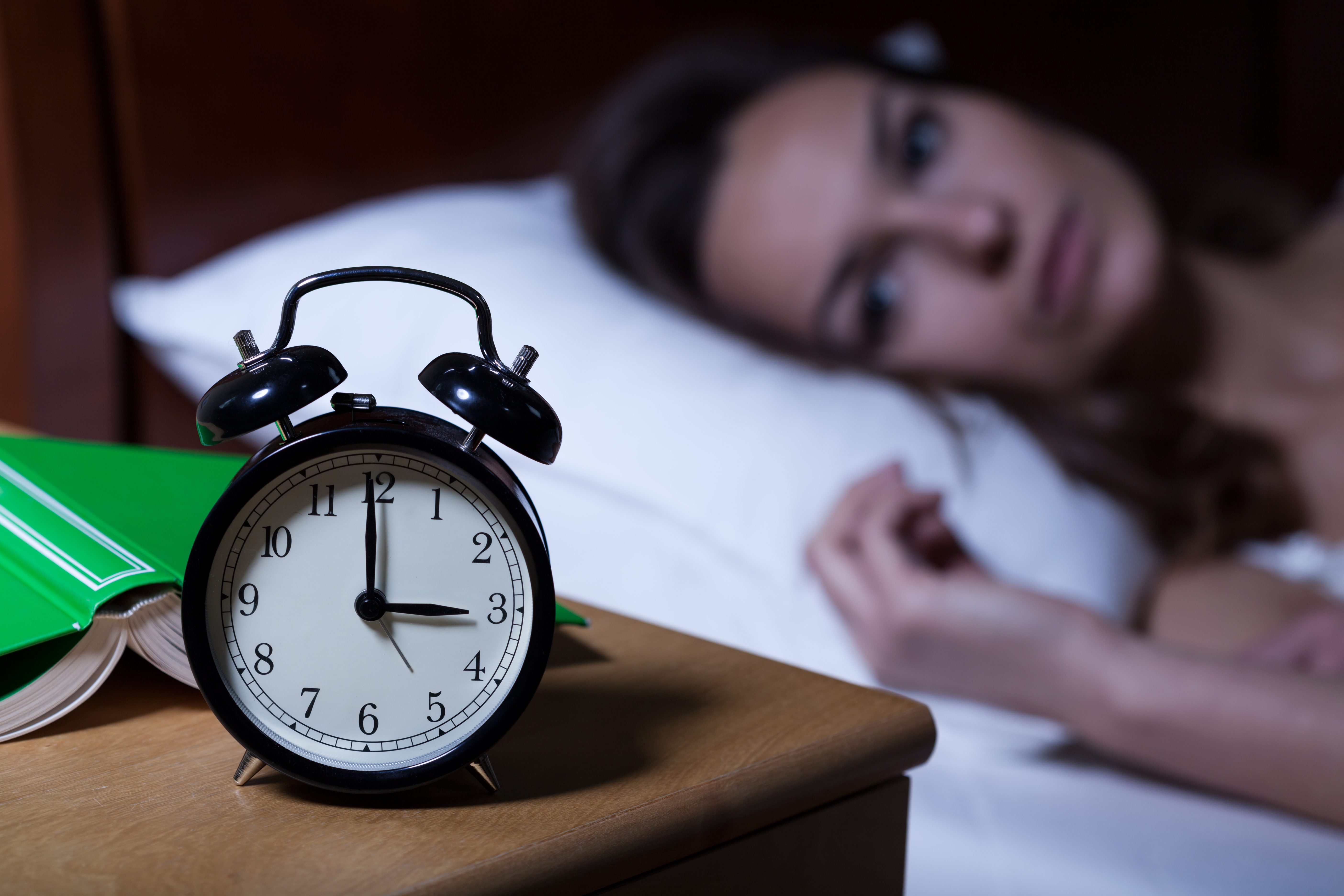 woman watching clock unable to sleep 